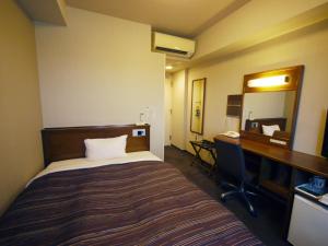 a room with a bed and a desk and a mirror at Hotel Route-Inn Mito Kencho-mae in Mito +29 photos