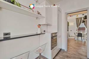 a kitchen with white cabinets and a dining room at Graffiti House Luxury Apartment in La Spezia