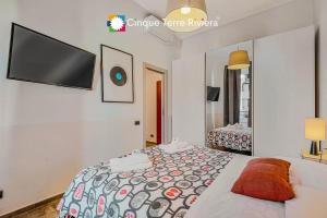 a bedroom with a bed and a flat screen tv at Graffiti House Luxury Apartment in La Spezia