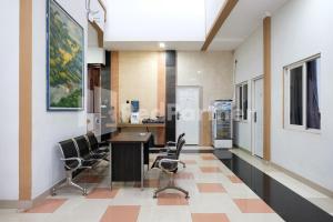 a kitchen with a table and chairs in a room at Aster Triplets Guest House JCM Mitra RedDoorz in Yogyakarta