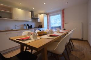 a kitchen with a long wooden table and chairs at GO FOR MOUNTAINS Appartements in Eben im Pongau +19 photos