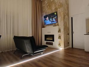 a living room with a chair and a television at Fenili Belasi - appartamento con giardino a 5min da Brescia in Castel Mella