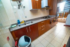 a kitchen with wooden cabinets and a sink and a toilet at LOUMIA Residency in Douala