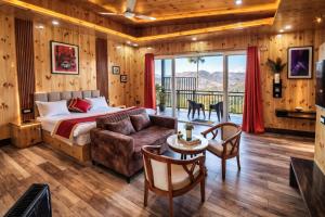 a bedroom with a bed and a couch and a table at Pine Country Resort in Mukteshwar