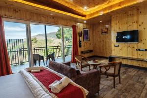 a living room with a couch and a large window at Pine Country Resort in Mukteshwar