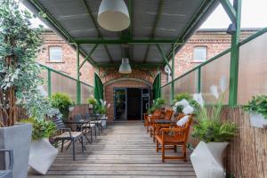 an outdoor patio with chairs and tables and plants at Hotel Przystanek Torun in Toruń