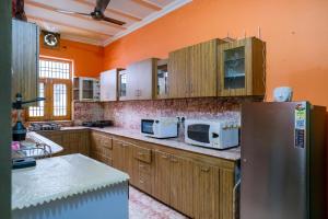 a kitchen with wooden cabinets and a stainless steel refrigerator at Meraki Homes in Karnal