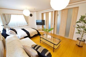 a living room with two beds and a couch at 伯旺ビル 403 in Kanazawa +63 photos