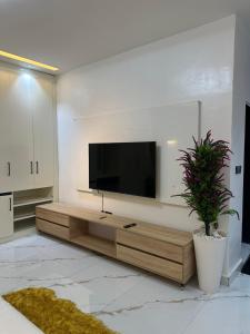 a living room with a flat screen tv on a wall at Emerald Enclave Residence in Gwarinpa