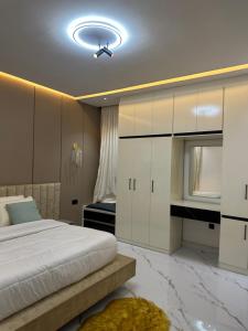 a bedroom with a bed and white cabinets at Emerald Enclave Residence in Gwarinpa