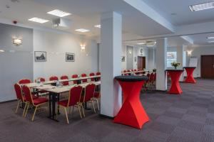 a conference room with tables and chairs and red stools at Hotel Przystanek Torun in Toruń