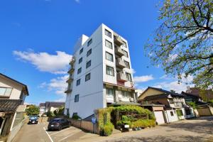 a tall white building on the side of a street at 伯旺ビル 403 in Kanazawa