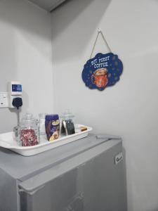 a sign hanging on a wall above a refrigerator at Happy Dany Stays in Kiahuria