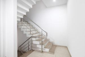 a metal staircase in a white room with white walls at FabHotel Shivay in Indore