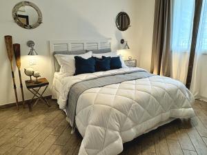 a bedroom with a large white bed with blue pillows at Scirocco - Villa Marina in Marina di Andora