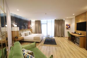 a hotel room with a bed and a desk at White Hill Hotel, SPA & Conferences in Durrës