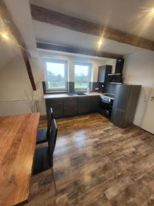 a kitchen with a wooden table and some windows at Ferienwohnung Barfelde in Dötzum