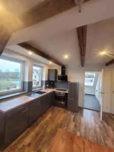 a kitchen with black cabinets and wooden floors at Ferienwohnung Barfelde in Dötzum