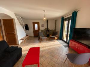 a living room with a couch and a flat screen tv at La Villa Soleil in Veynes