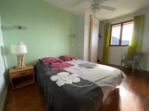 a bedroom with a bed and a lamp and a window at La Villa Soleil in Veynes