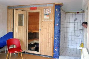 a small bathroom with a shower and a red chair at Öko-Appartement Melanie in Schwollen +19 photos