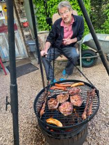 a man sitting in a chair next to a grill at Öko-Appartement Melanie in Schwollen