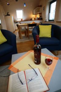 a bottle of wine sitting on a table with a book and glasses at Öko-Appartement Melanie in Schwollen