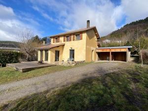 a large yellow house on a hill with a driveway at La Villa Soleil in Veynes