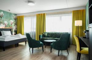 a living room with a couch and a table and chairs at Thon Hotel Ski in Ski