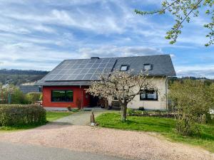 a house with solar panels on the roof at Öko-Appartement Melanie in Schwollen