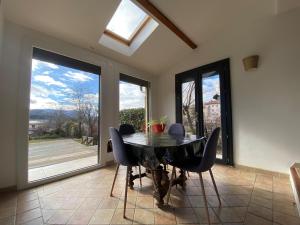 a dining room with a black table and chairs at La Villa Soleil in Veynes