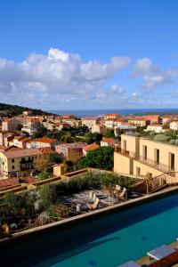 a view of a city and a swimming pool at Hôtel Mylos - Cargèse, Piscine Intérieure et Extérieure in Cargèse