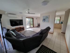 a living room with a couch and a flat screen tv at Welcome to Seascapes in Tin Can Bay