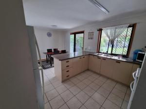 a large kitchen with a counter and a table at Welcome to Seascapes in Tin Can Bay +7 photos