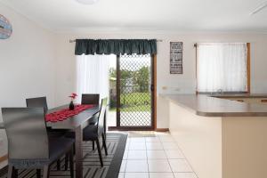 a kitchen and dining room with a table and chairs at Welcome to Seascapes in Tin Can Bay