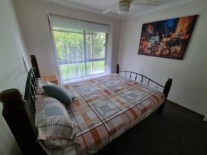 a bedroom with a bed and a window at Welcome to Seascapes in Tin Can Bay