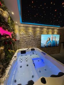 a bath tub in a room with a tv at Maison in Maisdon-sur-Sèvre