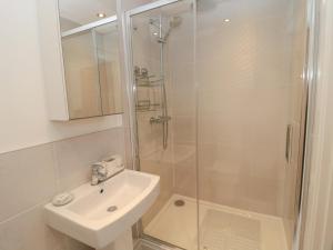 a white bathroom with a sink and a shower at Summer Rose in Craster +25 photos
