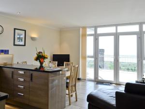 a living room with a kitchen and a dining room at Pendine Beach Apartment in Pendine