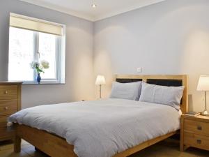 a bedroom with a large bed and a window at Pendine Beach Apartment in Pendine