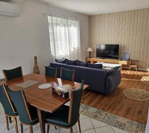 a living room with a table and a blue couch at La Belle des Pins in Mimizan