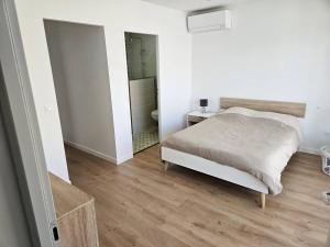 a bedroom with a bed and a walk in shower at La Belle des Pins in Mimizan