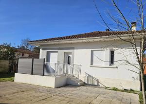 a white house with a porch and a balcony at La Belle des Pins in Mimizan