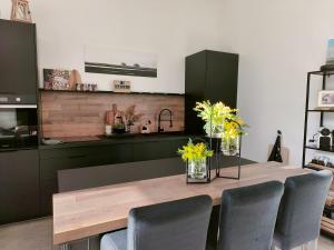 a kitchen with a wooden table with chairs around it at Hang'Ares, espace unique entre Bassin et Océan in Arès +22 photos