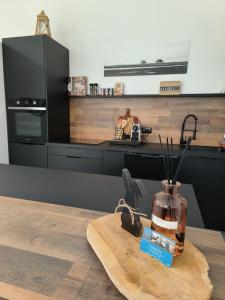 a kitchen with a vase on a wooden cutting board at Hang'Ares, espace unique entre Bassin et Océan in Arès