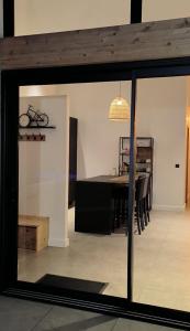 a dining room with a table and a glass window at Hang'Ares, espace unique entre Bassin et Océan in Arès