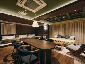 a hotel room with a table and chairs and a bedroom at illi Eme Tokyo-Toranomon in Tokyo