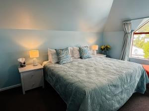 a bedroom with a bed with two lamps and a window at Seaview Akaroa in Akaroa +65 photos