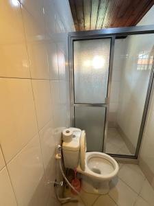 a small bathroom with a toilet and a shower at Kituri Hostel in Dar es Salaam