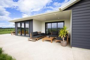 a patio with two couches and chairs on a house at Mahaki Escape in Pahautea